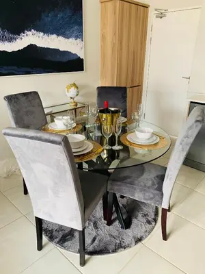 a dining room with a glass table and chairs at Luxury Holiday Homes - The Blyde in Pretoria