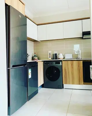 a kitchen with a dishwasher and a washer at Luxury Holiday Homes - The Blyde in Pretoria