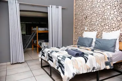 a bedroom with a bed and a mirror at Falcon Lodge (S) in Bela-Bela