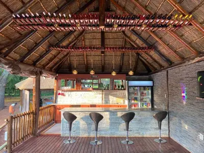 a bar on a deck with chairs around it at Falcon Lodge (S) in Bela-Bela