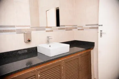 a bathroom with a white sink and a mirror at Falcon Lodge (S) in Bela-Bela