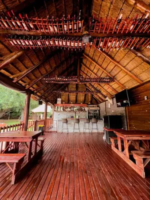 a large wooden deck with benches and a bar at Falcon Lodge (S) in Bela-Bela