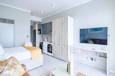 a white room with a bed and a tv at Menlyn Maine Luxury Apartments 11th & 14th floor with Balcony in Pretoria