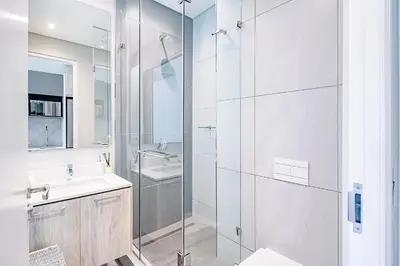 a white bathroom with a sink and a shower at Menlyn Maine Luxury Apartments 11th & 14th floor with Balcony in Pretoria