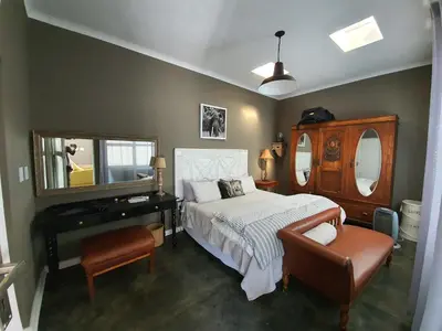 a bedroom with a bed and a mirror and a piano at Waterhouse Guest Lodge in Waterkloof in Pretoria