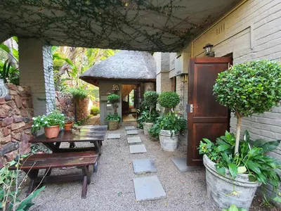a patio with a table and a gazebo with plants at Waterhouse Guest Lodge in Waterkloof in Pretoria