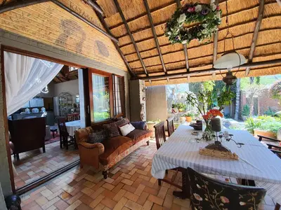a living room with a table and a couch at Waterhouse Guest Lodge in Waterkloof in Pretoria