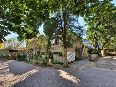 a house with a lot of trees and a driveway at Waterhouse Guest Lodge in Waterkloof in Pretoria