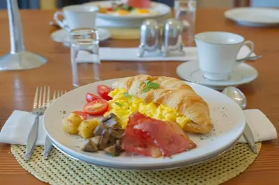 a plate with a breakfast sandwich on a table at Osborne House in Pretoria