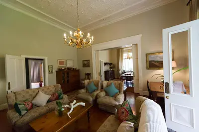 a living room with couches and a chandelier at Osborne House in Pretoria