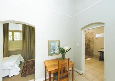 a room with a table and a bed and a bedroom at Osborne House in Pretoria