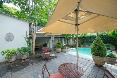 a patio with a large umbrella and a pool at Osborne House in Pretoria