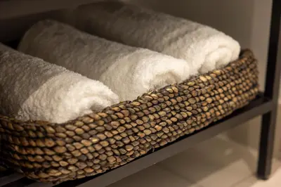 a basket of towels on a shelf in a bathroom at The Cassini Diamond @ Ellipse Waterfall in Midrand