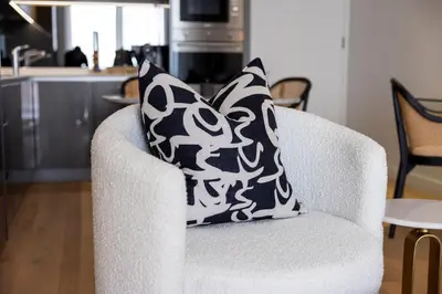 a black and white pillow on a white chair at The Cassini Diamond @ Ellipse Waterfall in Midrand