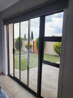 an open sliding glass door with a view of a yard at M & N Guest House in Ermelo