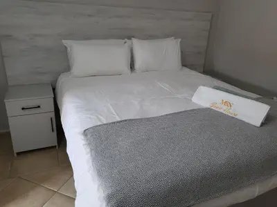 a white bed with a napkin on top of it at M & N Guest House in Ermelo