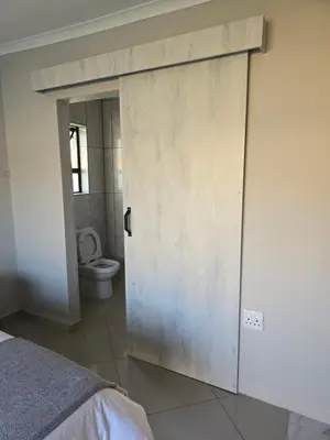 a door to a bathroom with a toilet in a room at M & N Guest House in Ermelo