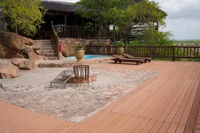 a patio with two chairs and a bench on a deck at Lucca Lodge in Musina