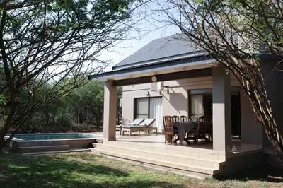 a pavilion with a table and chairs in a yard at Villa Fika Futi in Hoedspruit