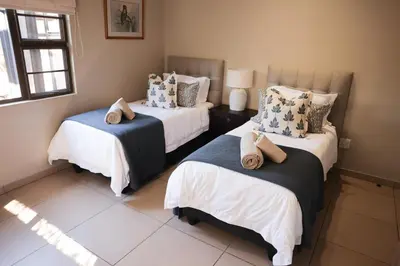 a bedroom with two beds with pillows on them at Villa Fika Futi in Hoedspruit