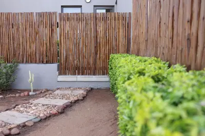 a garden with a wooden fence and a cactus at Villa Fika Futi in Hoedspruit