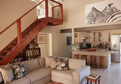 a living room with a couch and a kitchen at Villa Fika Futi in Hoedspruit