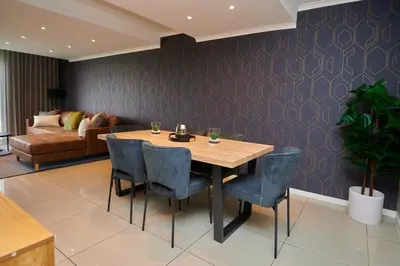 a dining room with a table and chairs and a couch at Unit 404 at Menlyn Place in Pretoria