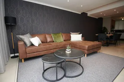 a living room with a brown couch and a table at Unit 404 at Menlyn Place in Pretoria