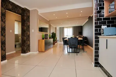 a kitchen and living room with a table and chairs at Unit 404 at Menlyn Place in Pretoria