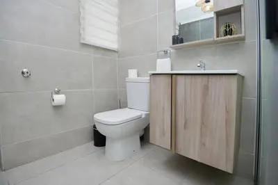 a bathroom with a white toilet and a sink at Unit 404 at Menlyn Place in Pretoria