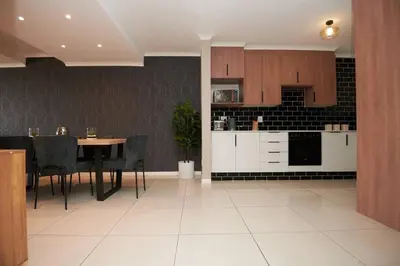 a kitchen and dining room with a table and chairs at Unit 404 at Menlyn Place in Pretoria