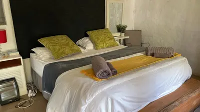 two beds in a room with towels on them at Tjimaka Farm in Hazyview