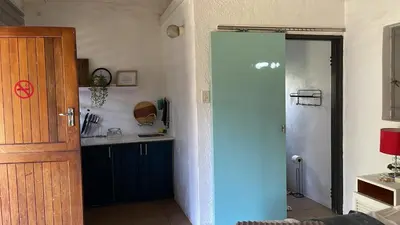 a kitchen with a blue door and a counter at Tjimaka Farm in Hazyview