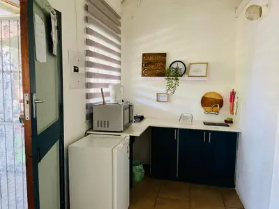 a small kitchen with a refrigerator and a microwave at Tjimaka Farm in Hazyview