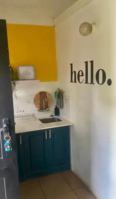 a kitchen with a sink and ahello sign on the wall at Tjimaka Farm in Hazyview