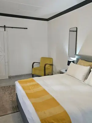 a bedroom with a large bed and a yellow chair at 43 Home apartment in Del Judor