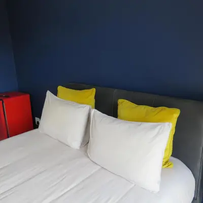 a bed with three white pillows and two yellow pillows at 43 Home apartment in Del Judor