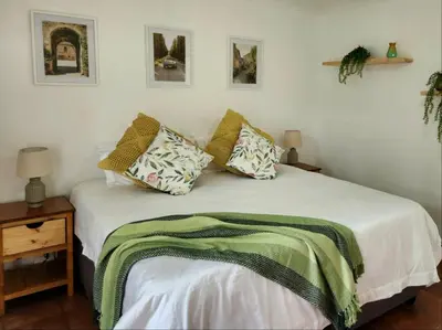 a bedroom with a bed with a green blanket on it at Baruch in Pretoria