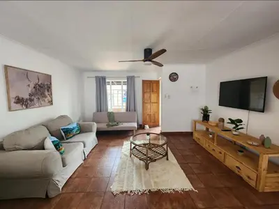 a living room with a couch and a flat screen tv at Baruch in Pretoria