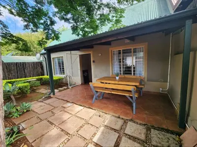 a bench sitting on a patio in front of a house at Baruch in Pretoria