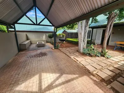 a pavilion with a brick patio with a tree at Baruch in Pretoria