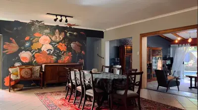 a dining room with a large painting on the wall at Elizabeth the 7th in Tzaneen