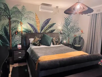 a bedroom with a bed with plants on the wall at Elizabeth the 7th in Tzaneen
