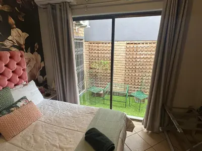 a bedroom with a bed and a large window with a view at Elizabeth the 7th in Tzaneen