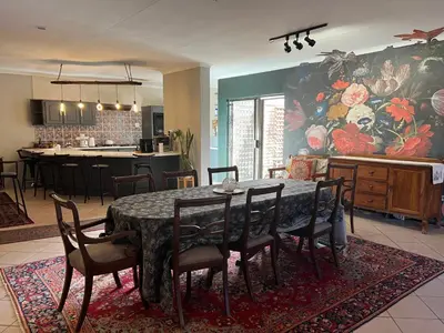 a dining room with a table and chairs and a kitchen at Elizabeth the 7th in Tzaneen