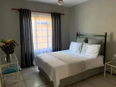 a bedroom with a large bed with a window at Pendleberry Grove Unit 36 in Bela-Bela