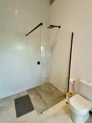a bathroom with a glass shower and a toilet at Corkwood Villa in Hoedspruit