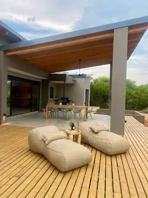 a wooden deck with two bean bags on a patio at Corkwood Villa in Hoedspruit