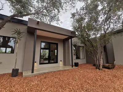 a small house with a tree in front of it at Corkwood Villa in Hoedspruit