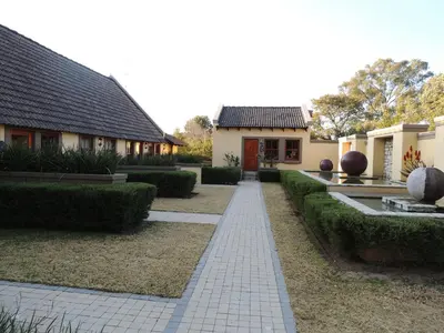 a house with a walkway in front of a yard at Strawberry Fields Country Manor Guest House in Johannesburg